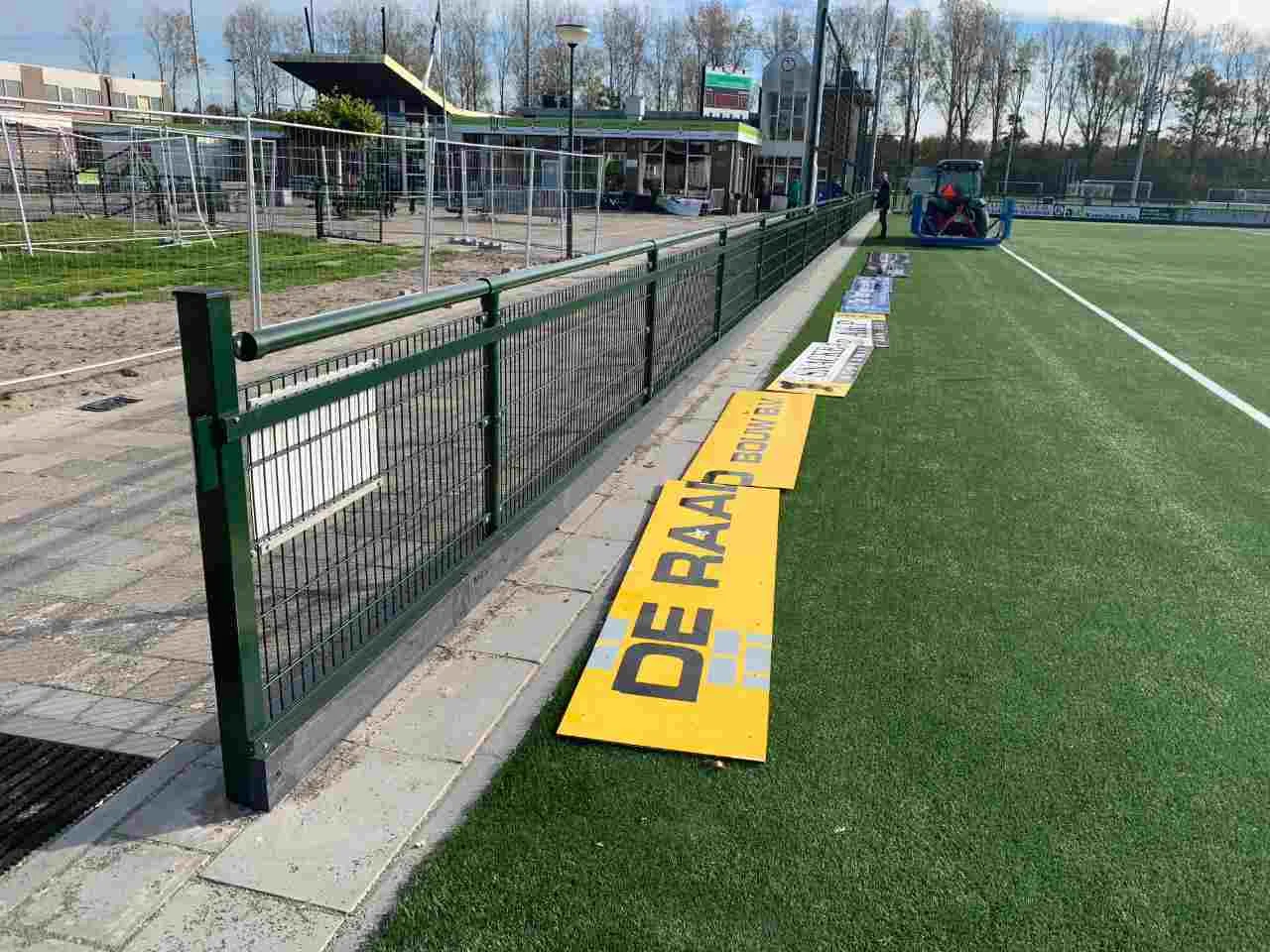 Dennengroene reclameprofielen op sportpark Lageweg
